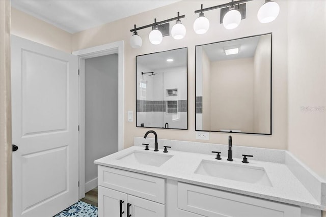 full bath with double vanity, a shower, a sink, and wood finished floors