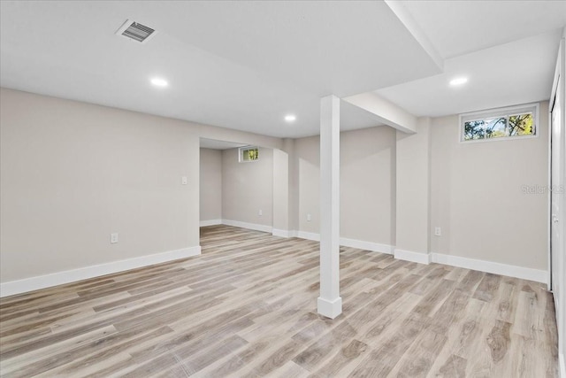 below grade area featuring light wood-style floors, recessed lighting, visible vents, and baseboards