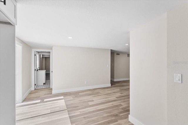 spare room with recessed lighting, light wood-type flooring, and baseboards