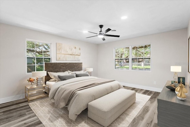 bedroom with a ceiling fan, baseboards, and wood finished floors