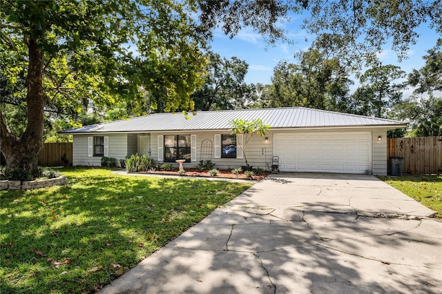 ranch-style house featuring a front yard and a garage