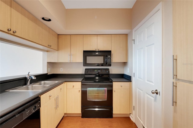 kitchen with light brown cabinets, black appliances, and sink