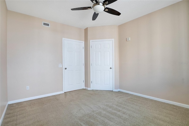 carpeted spare room featuring ceiling fan