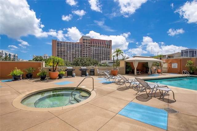 view of swimming pool with a patio area and a hot tub