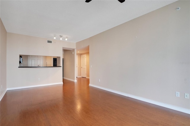 unfurnished living room with ceiling fan, baseboards, wood finished floors, and visible vents