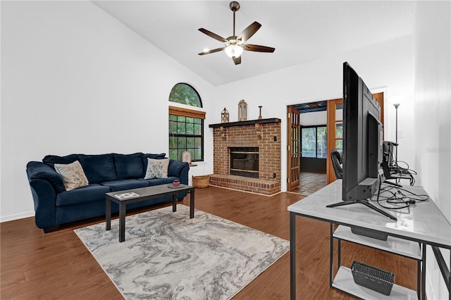 living room with dark hardwood / wood-style floors, ceiling fan, a brick fireplace, and plenty of natural light