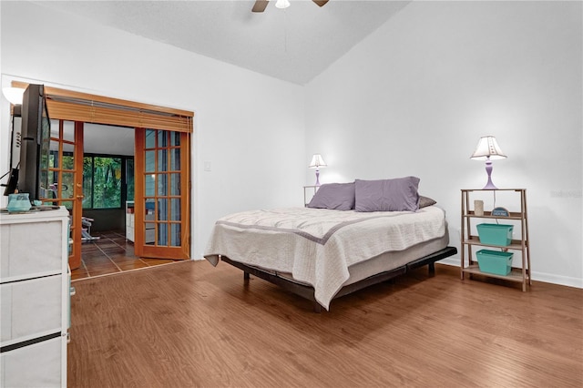 bedroom with ceiling fan, hardwood / wood-style flooring, and lofted ceiling