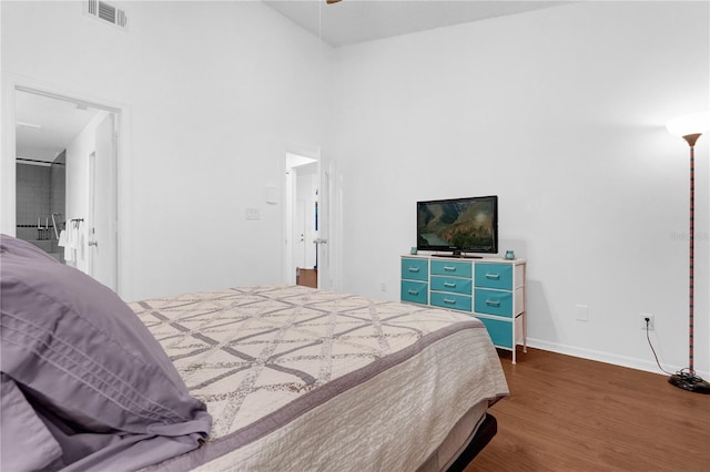 bedroom featuring dark wood-type flooring and a high ceiling