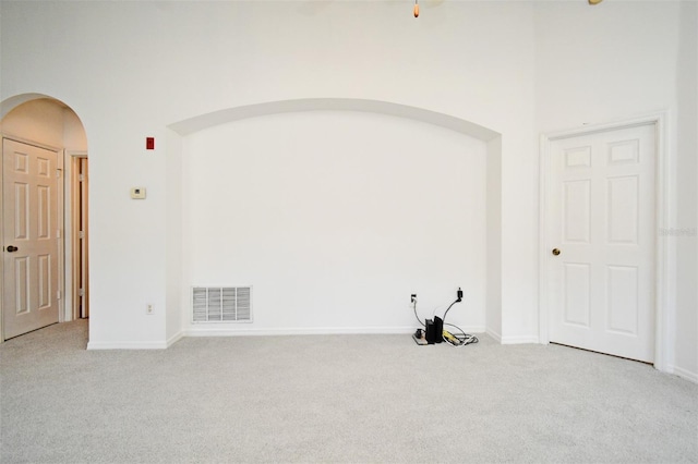 570 Cranes Way Unit 248, Altamonte Springs, FL 32701 - unfurnished room with light carpet, arched walkways, a high ceiling, and baseboards