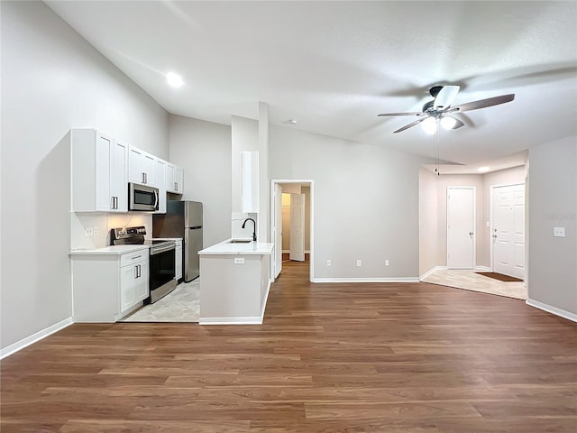 kitchen featuring ceiling fan, white cabinets, appliances with stainless steel finishes, and light hardwood / wood-style floors