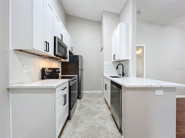 kitchen featuring sink, lofted ceiling, kitchen peninsula, white cabinetry, and stainless steel appliances