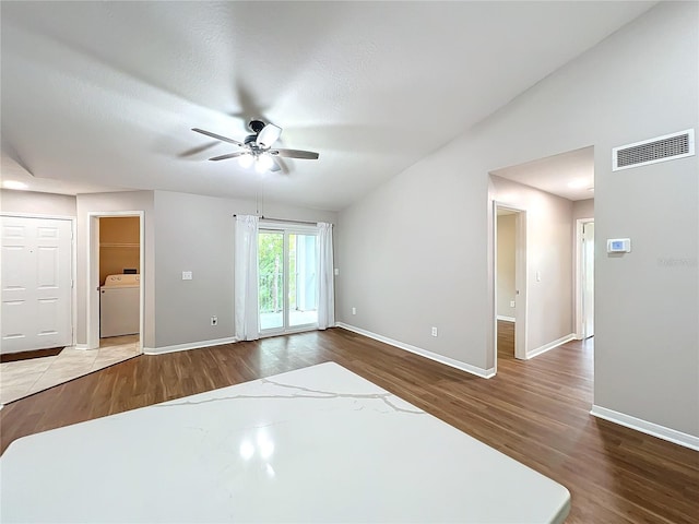 spare room featuring ceiling fan, a textured ceiling, hardwood / wood-style floors, and washer / dryer