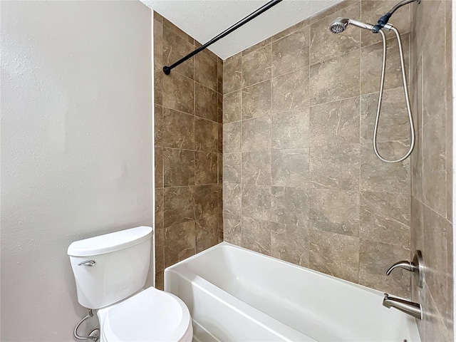 bathroom featuring tiled shower / bath and toilet