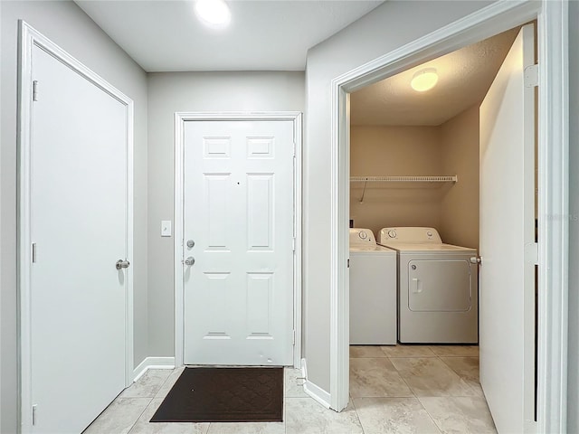 clothes washing area featuring washing machine and clothes dryer and light tile patterned flooring