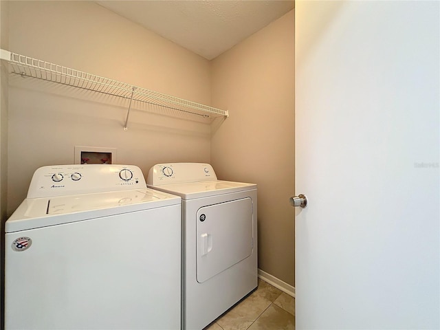 laundry room with independent washer and dryer and light tile patterned floors