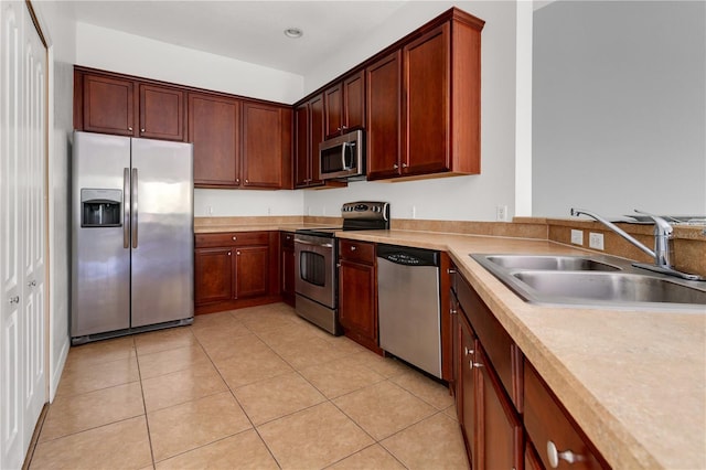 kitchen featuring light tile patterned floors, stainless steel appliances, and sink