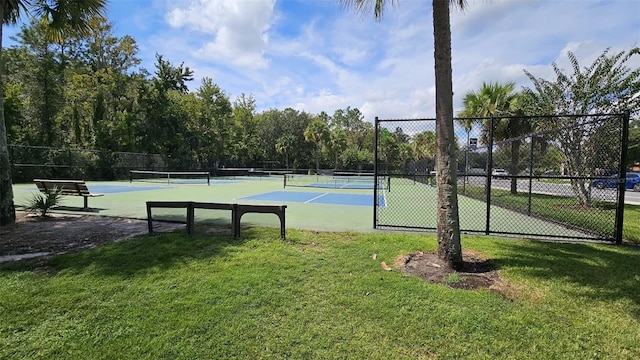 view of tennis court featuring a lawn