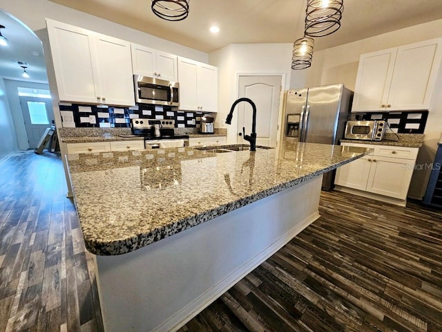 kitchen featuring dark hardwood / wood-style floors, sink, white cabinets, hanging light fixtures, and stainless steel appliances