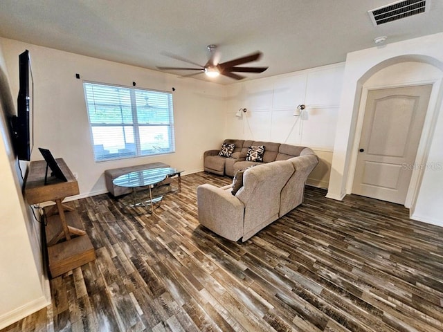 living room with ceiling fan and dark hardwood / wood-style flooring