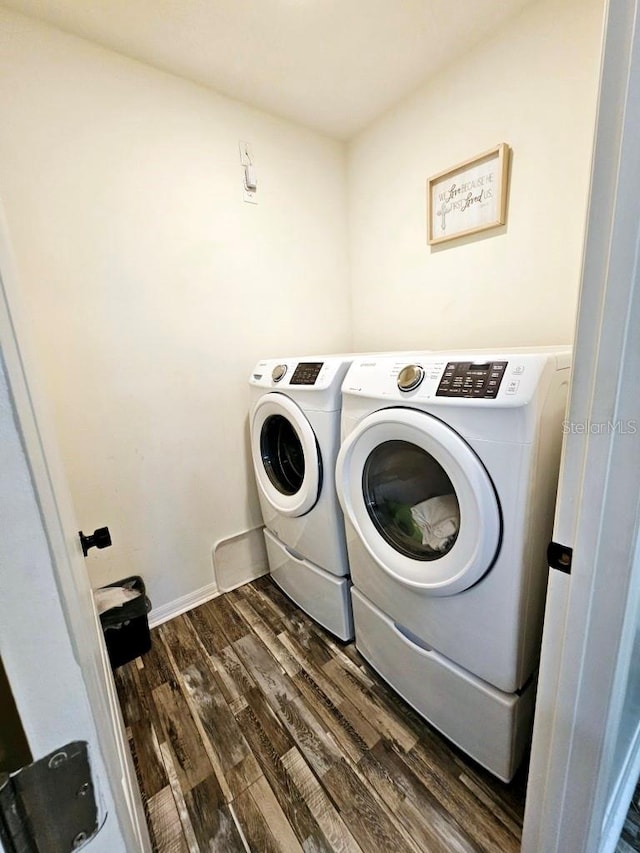 laundry room with independent washer and dryer and dark hardwood / wood-style flooring