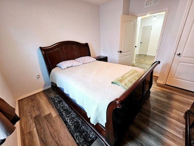 bedroom with dark hardwood / wood-style floors