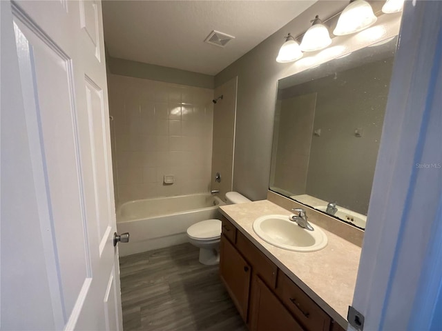 full bathroom featuring wood-type flooring, vanity, toilet, and tiled shower / bath