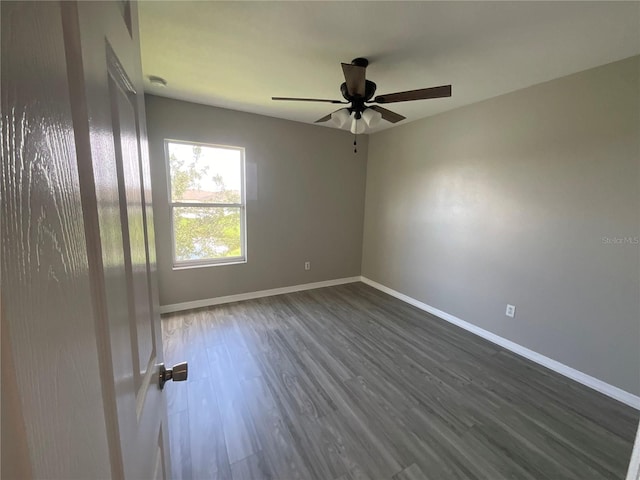 unfurnished room with dark hardwood / wood-style flooring and ceiling fan