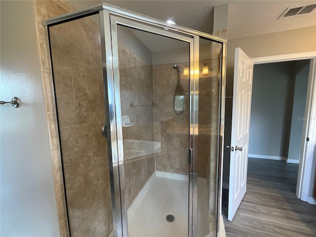 bathroom featuring hardwood / wood-style flooring and an enclosed shower