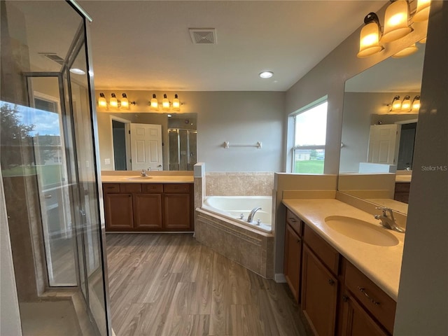 bathroom featuring vanity, hardwood / wood-style floors, and separate shower and tub