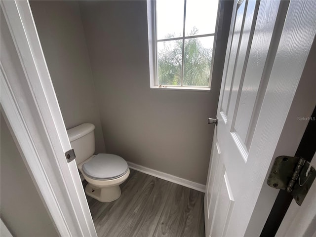 bathroom with toilet and hardwood / wood-style flooring