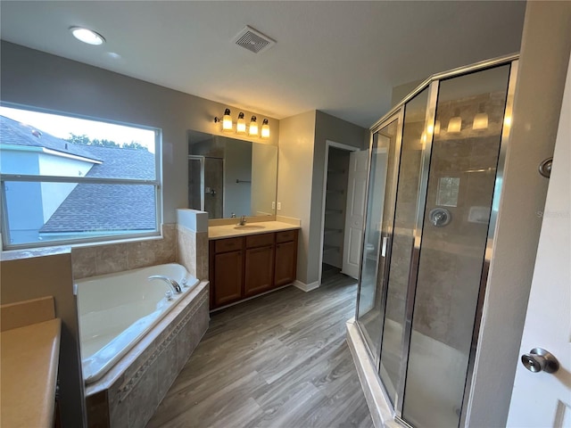 bathroom featuring vanity, separate shower and tub, and hardwood / wood-style flooring