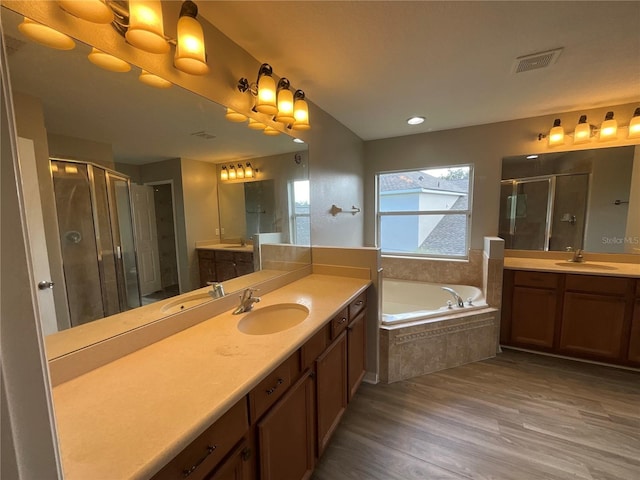 bathroom featuring shower with separate bathtub, vanity, and wood-type flooring