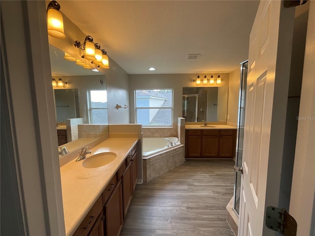 bathroom with shower with separate bathtub, vanity, and wood-type flooring