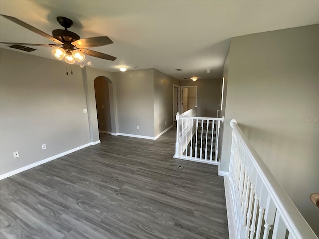 empty room with ceiling fan and dark hardwood / wood-style flooring