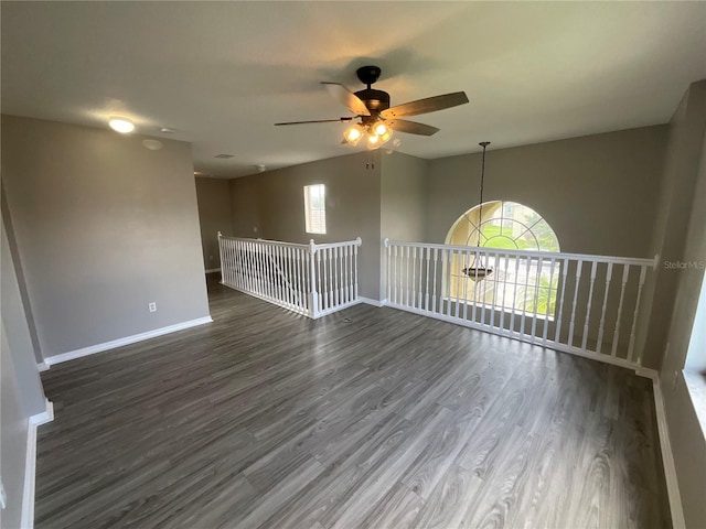 spare room featuring ceiling fan, dark hardwood / wood-style flooring, and a healthy amount of sunlight