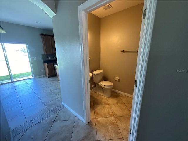 bathroom with toilet and tile patterned floors