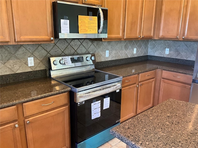 kitchen with decorative backsplash, appliances with stainless steel finishes, and light tile patterned floors