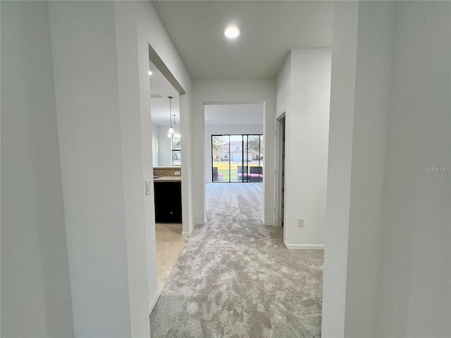 hall featuring light colored carpet