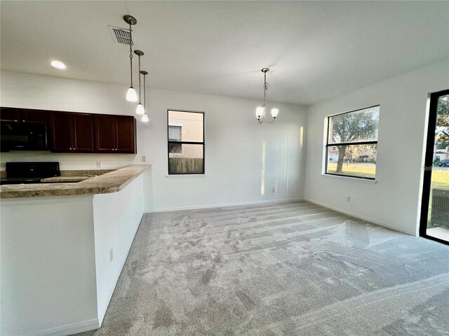 kitchen featuring light carpet, black appliances, a chandelier, and decorative light fixtures