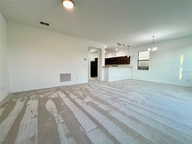 unfurnished living room with light carpet and a notable chandelier