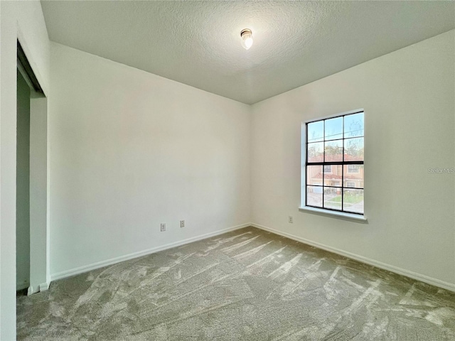 unfurnished room with a textured ceiling and light colored carpet