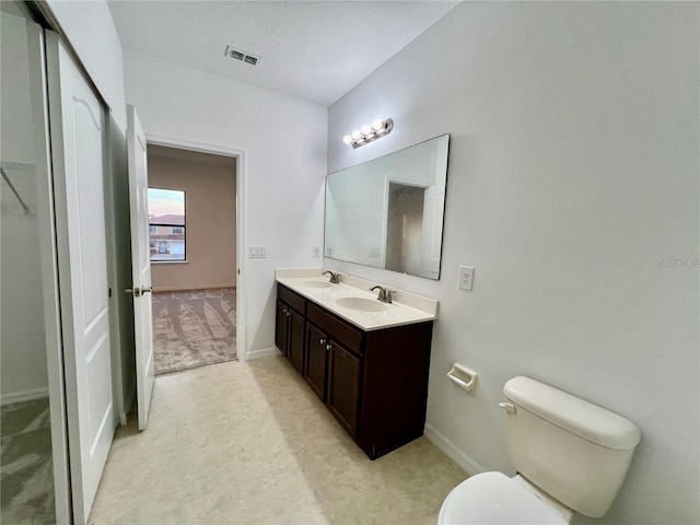 bathroom with vanity, toilet, and a textured ceiling