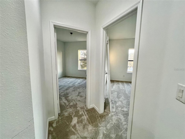 hallway featuring dark colored carpet