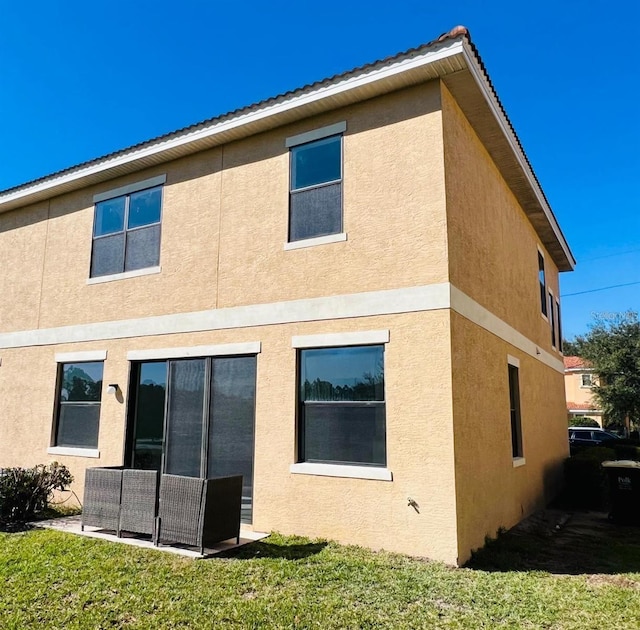 rear view of property with a yard and a patio