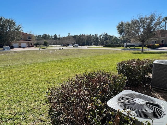 view of yard with central AC unit and a garage