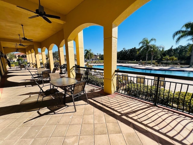 view of patio with a community pool and ceiling fan