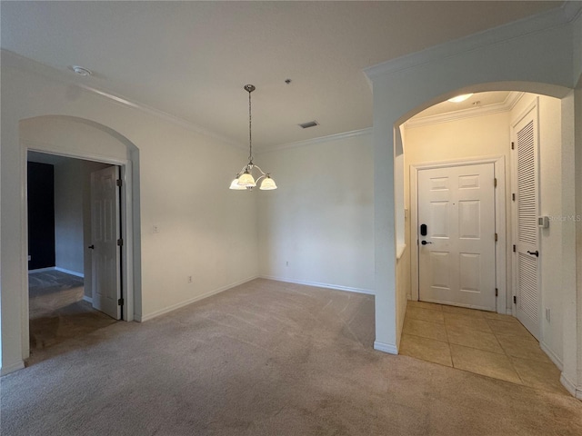 carpeted spare room with crown molding and a notable chandelier