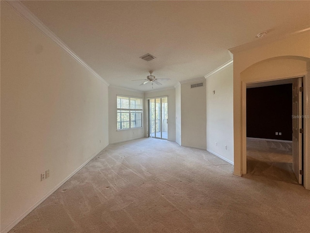 carpeted empty room with ceiling fan and crown molding