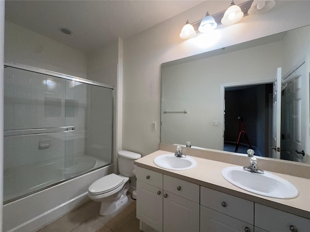 full bathroom featuring tile patterned flooring, shower / bath combination with glass door, toilet, and vanity