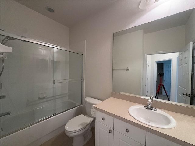 full bathroom featuring enclosed tub / shower combo, vanity, and toilet